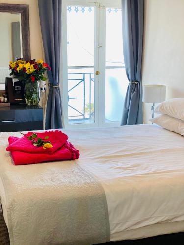 a bedroom with a large bed with a vase of flowers on it at Villa Mentone Hotel in Shanklin