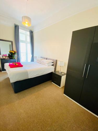 a bedroom with a large bed and a black cabinet at Villa Mentone Hotel in Shanklin