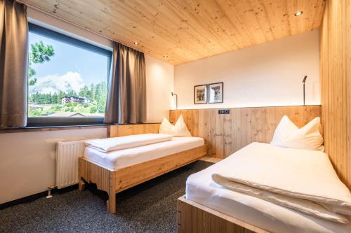 2 camas en una habitación con ventana en s'Hoamatl Dorfkrug Appartements, en Seefeld in Tirol