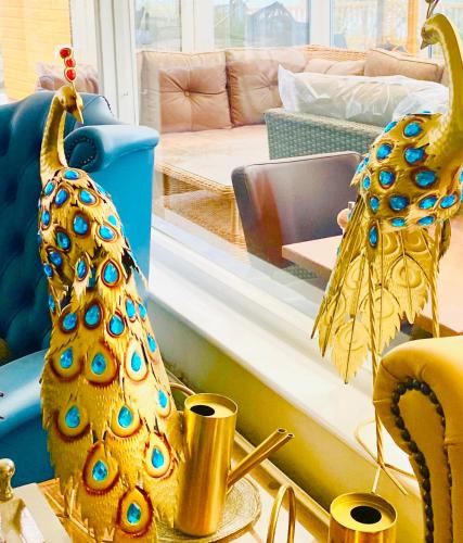a living room with a peacock decoration on a table at Villa Mentone Hotel in Shanklin