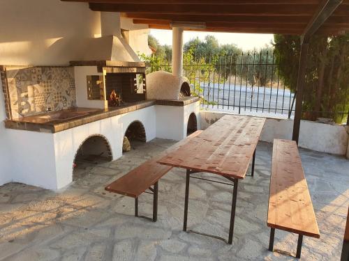 a patio with a wooden table and a fireplace at Hotel Pefko in Neos Marmaras