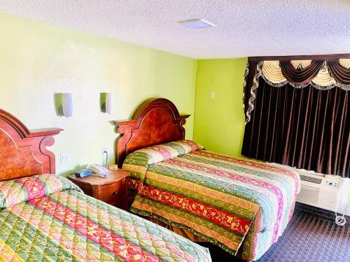 a hotel room with two beds and a window at A Fisher's Inn Motel in Las Vegas