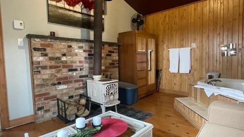 a living room with a brick fireplace and a stove at Auberge et Chalets sur le Lac in Lac-Mégantic