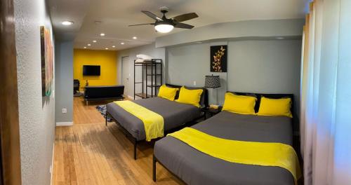 two beds in a room with yellow and gray at The Mammoth Inn in Mammoth Lakes