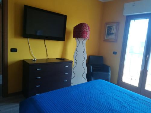 1 dormitorio con cama, lámpara y TV en Romanina Appartamento Giuland en Roma