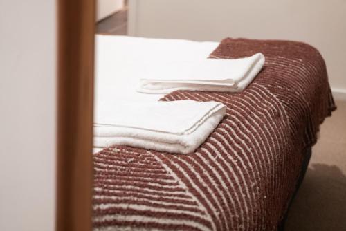 una pila de toallas sentadas encima de un sofá en The Tatler Lodge, en Lovedale