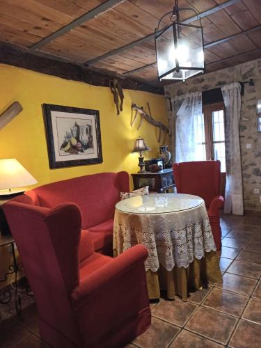 sala de estar con mesa y sillas rojas en LA HUETA Bajo, en Orcera