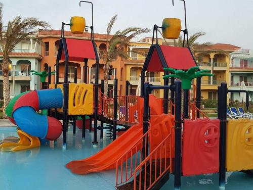 un parque infantil frente a un edificio en Porto Matruh - Your Family's Peaceful Summer Stay, en Marsa Matruh