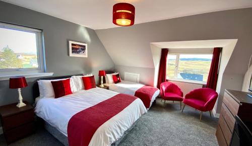a bedroom with two beds and two red chairs at Blacksmith holiday cottage near Portree in central Skye in Portree
