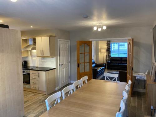 a kitchen and living room with a table and chairs at Hopefield Premium Holiday Home Portrush Sleeps 10 4 bedrooms in Portrush