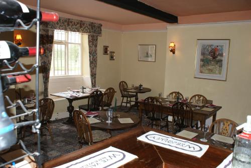 a dining room with tables and chairs and a window at The Red Lion Hotel in Bredwardine