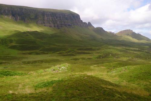 a green field with a mountain in the background at Uig Chalets Idrigill Hill Chalet in Uig