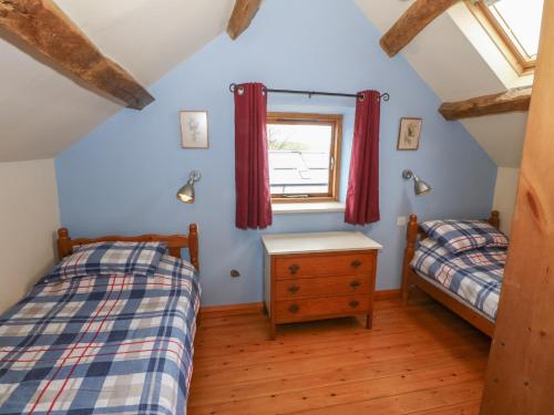 two twin beds in a room with a window at The Grain Store in Abersoch