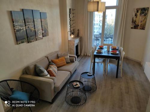 uma sala de estar com um sofá e uma mesa em Pretty and quiet top floor 2 bedroom flat in the port area of Nice em Nice