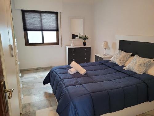 a bedroom with a blue bed and a window at Alojamiento Carmen Baja (centro Almuñécar) in Almuñécar