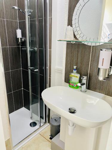 a bathroom with a sink and a shower at Villa Mentone Hotel in Shanklin