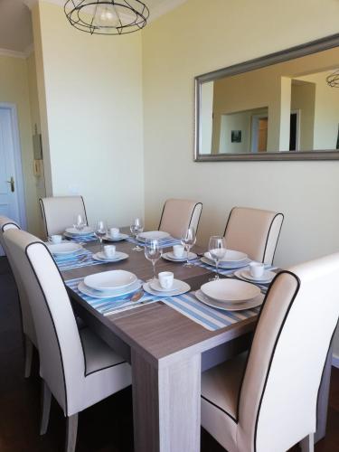 a dining room table with chairs and a large mirror at Sol & Mar Camara de Lobos in Câmara de Lobos