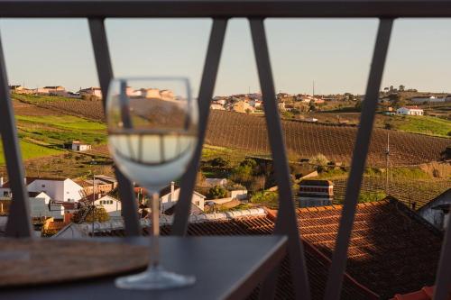 a wine glass sitting on a balcony with a view at Gamboas Place in Olhalvo