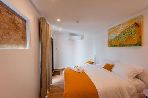 una camera da letto con un letto e un dipinto sul muro di Gamboas Place a Olhalvo