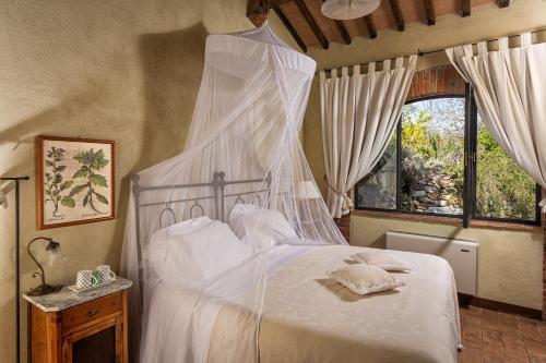 um quarto com uma cama de dossel branca em Villa Cicolina em Montepulciano