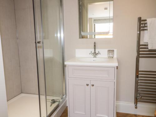 biała łazienka z umywalką i prysznicem w obiekcie Owl's Hoot w mieście Hull