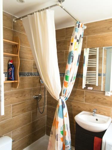 une salle de bain avec un rideau de douche et un lavabo dans l'établissement Saint Georges - ParisSmile, à Villeneuve-Saint-Georges