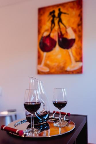 two glasses of red wine sitting on a tray at Gamboas Place in Olhalvo