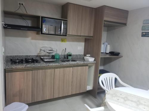 a kitchen with a counter with a sink and a microwave at Flats Angatu Porto de Galinhas PE in Porto De Galinhas