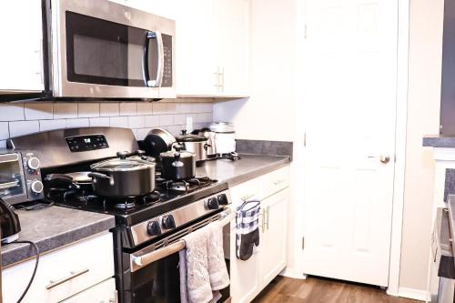 uma cozinha com um fogão e um micro-ondas em Easy Access luxurious kingbed with facilities yet to be opened em Norcross
