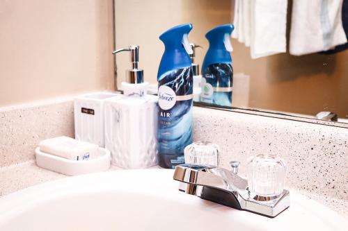 ein Waschbecken mit einer Flasche Mundwasser und einem Spiegel in der Unterkunft Easy Access luxurious kingbed with facilities yet to be opened in Norcross