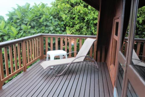 a white chair sitting on a wooden deck at Muri Vista Villas in Rarotonga