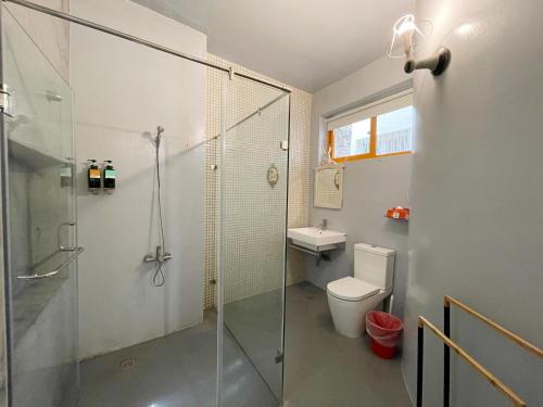 a bathroom with a shower and a toilet and a sink at Sennong Homestay in Tainan