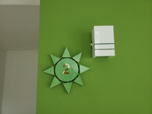 a green wall with a clock with a number in it at Flats Angatu Porto de Galinhas PE in Porto De Galinhas