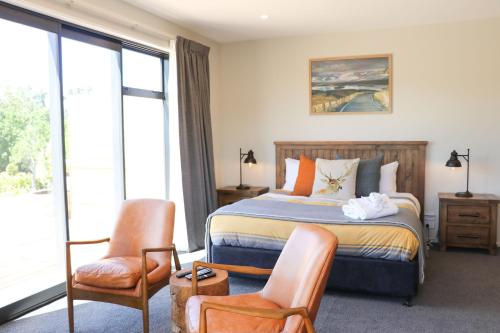 um quarto com uma cama, 2 cadeiras e uma janela em Fivestone Suite em Lake Tekapo