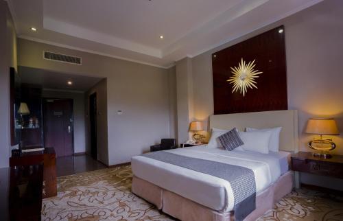 a bedroom with a large bed in a room at Sutanraja Hotel & Convention Centre in Soreang