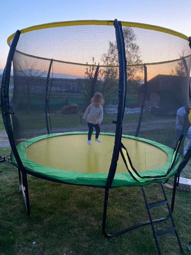 a young child playing on a trampoline at Brvnare Rodjak sa sela in Mionica