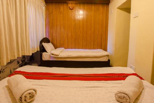 a room with two beds in a hotel room at Tulaja Boutique Hotel in Bhaktapur