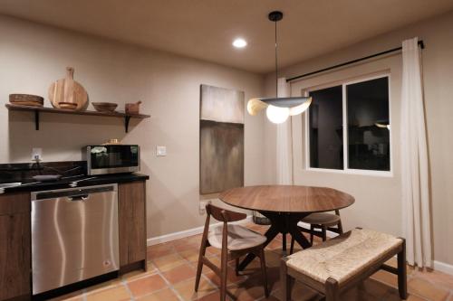 a kitchen with a table and chairs and a microwave at @ Marbella Lane - The Moon Designer Home right behind the JTNP in Joshua Tree