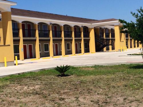 a large yellow building with red doors and windows at Super 8 by Wyndham San Antonio Near Fort Sam Houston in San Antonio