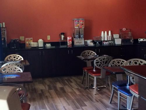 a restaurant with tables and chairs and a counter at Super 8 by Wyndham San Antonio Near Fort Sam Houston in San Antonio