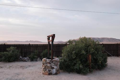a piece of equipment sitting in the sand next to a fence at @ Marbella Lane - The Moon Designer Home right behind the JTNP in Joshua Tree