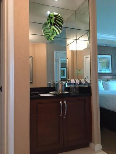 a bathroom with a vanity with a mirror and a bed at MGM Signature Condo Hotel by Owner - No Resort Fee !! in Las Vegas