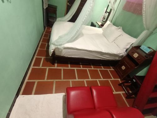 a room with two beds and a red chair at 彼岸古厝民宿-包棟優先--Biiann B&B in Jinning