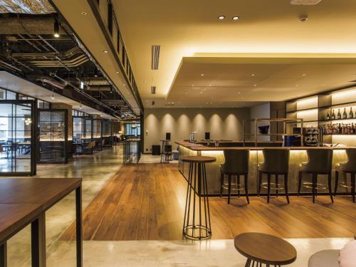 a bar in a restaurant with black stools at SHIBUYA STREAM HOTEL formerly Shibuya Stream Excel Hotel Tokyu in Tokyo