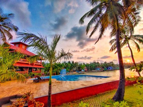 a resort with a swimming pool and palm trees at Paradise Lagoon in Kalyānpur