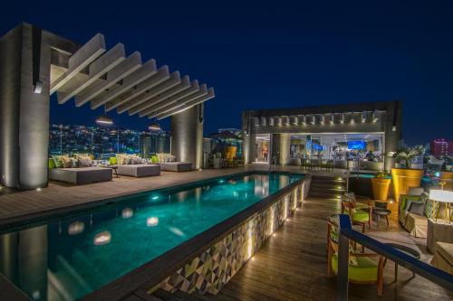 a pool on the rooftop of a hotel at night at K Tower Boutique Hotel By Lucerna in Tijuana