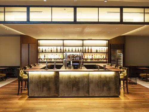 a bar in a restaurant with a lot of bottles at SHIBUYA STREAM HOTEL formerly Shibuya Stream Excel Hotel Tokyu in Tokyo