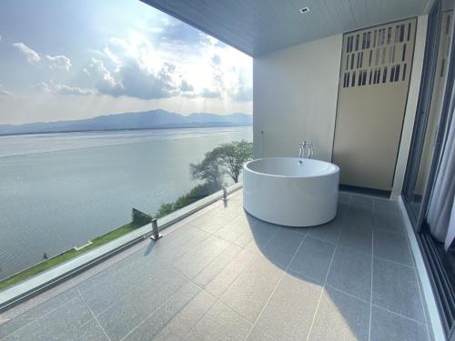 a bathroom with a tub and a view of the water at M2 Hotel Waterside in Phayao