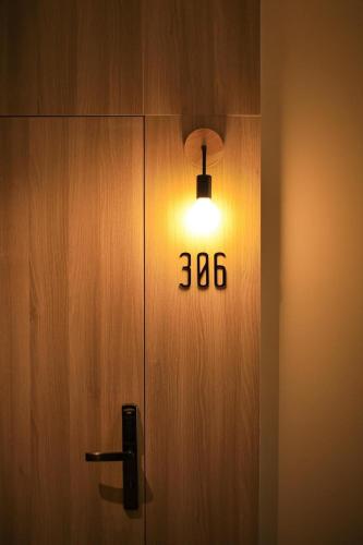 a light on a wooden door with the number at M2 Hotel Waterside in Phayao