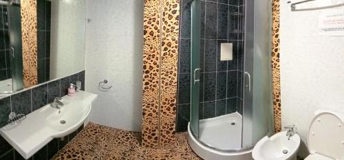 a bathroom with a shower and a toilet and a sink at АЛЬБЕРГО комнаты для отдыха у моря in Olginka